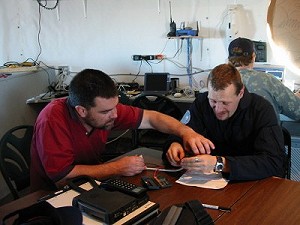 Markus Landgraf a K. Mark Caviezel spojují 9 pinový a 25 pinový kabely, aby byla jednotka MSAT funkční.