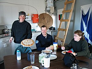 Posádka (Nell, Markus, Shannon) požívají pizzu, kterou přivezl Twin Otter na základnu.